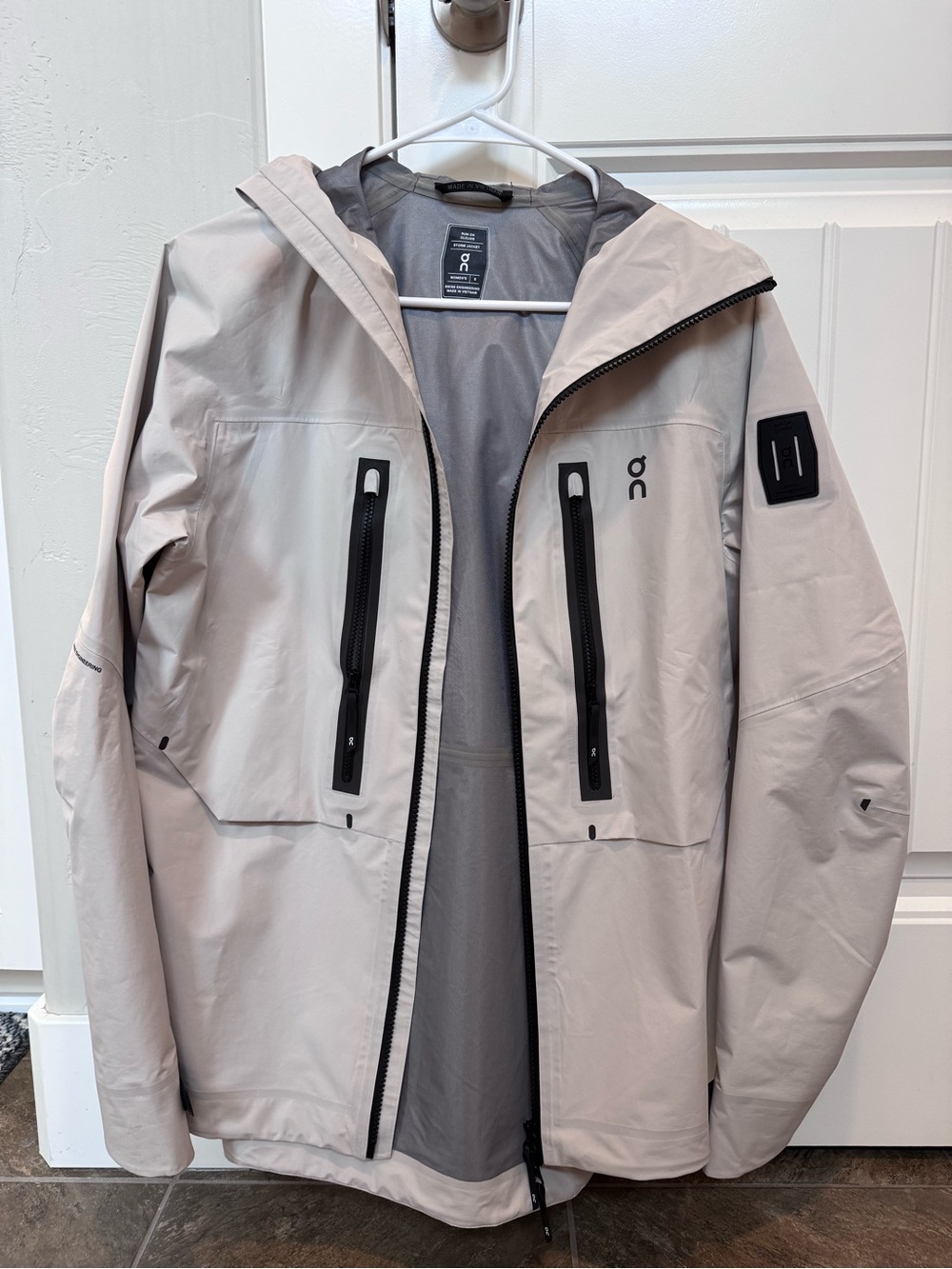 On Running Light Beige Hooded Raincoat with Black Zippers